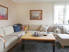 A living room with a sofa, a coffee table, and a painting on the wall. - 4 Star Holiday Home in Lysekil (Lysekil)