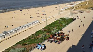 A beach with a paved walkway, benches, and a variety of people and vehicles. - Moorea City Center Apartment (Middelkerke)