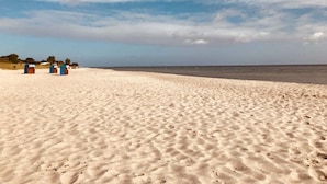 A sandy beach with three blue beach huts in the distance. - My Baltic Sea Place House by the sea 7 (Niesgrau)