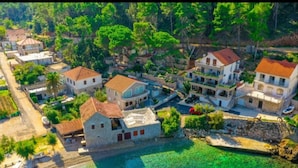 An aerial view of a coastal village with buildings, a clear blue sea, and lush greenery. - Apartments Vela Stiniva - Two Bedroom Apartment With Sea View and Terrace (Jelsa)