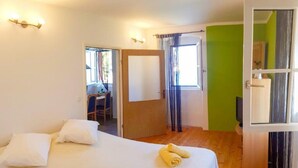 A hotel room with a bed, a desk, and a television. - Apartments Vela Stiniva - Two Bedroom Apartment With Sea View and Terrace (Jelsa)