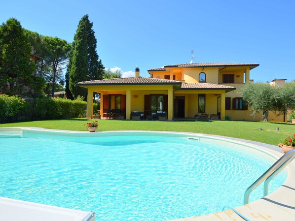 Ein zweistöckiges Haus mit einem Pool davor.