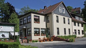 Un immeuble de deux étages avec un jardin à l’avant.