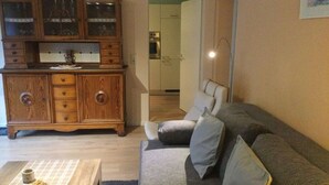 Un salon avec un meuble en bois, un canapé et une table basse.