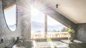 A bathroom with a stone sink, a mirror, and a window with a view of mountains. - Cosy Chalet in Wolting With Natural Swimming Pond (Tamsweg)
