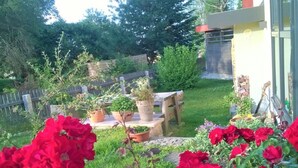 Un jardín con plantas en macetas y una mesa de madera.