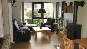 Una sala de estar moderna con sofá, sillón, mesa de centro y chimenea.