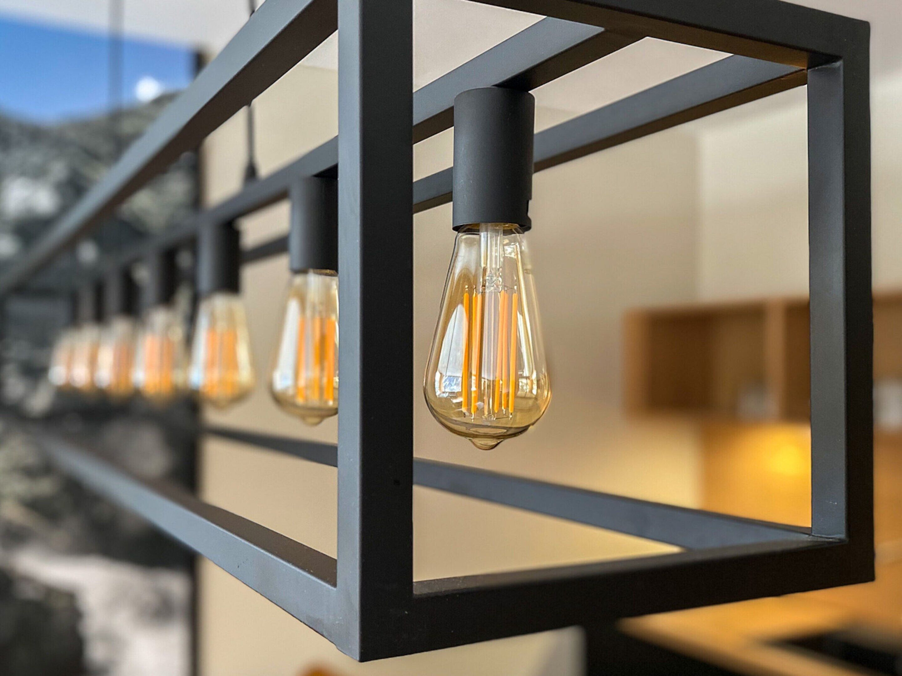 A row of modern pendant lights with a geometric metal frame.