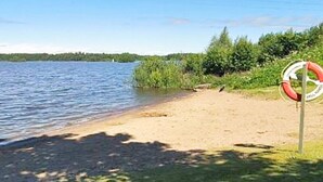 A lifebuoy on a sandy beach by a calm body of water. - 8 Person Holiday Home in Hallekis (Hallekis)