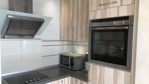 Uma cozinha moderna com forno embutido, micro-ondas e coifa.