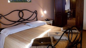 Ein Schlafzimmer mit einem Bett, einem Nachttisch und einem Gemälde mit Gänseblümchen an der Wand.