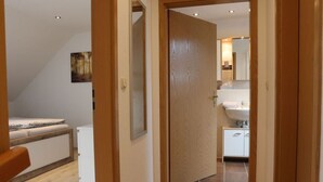 A bedroom with a bed, a bedside table, and a painting on the wall. - Holiday Home Mountain View (Langelsheim)