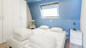 A bedroom with a bed, a nightstand, a chair, and a wardrobe. - Apartment Near the Grand Place (Blankenberge)