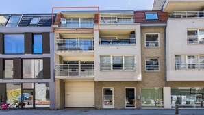 A multi-story residential building with balconies, large windows, and a garage. - Apartment Near the Grand Place (Blankenberge)