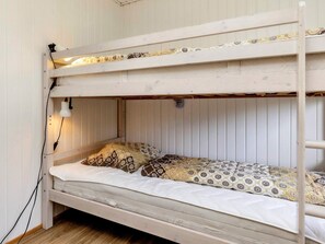 A bunk bed with two levels, a bedside lamp, and patterned bedding. - 7 Person Holiday Home in Hals (Hals)