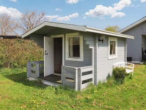 A small, single-story cabin with a porch, a door, and a window. - 7 Person Holiday Home in Hals (Hals)