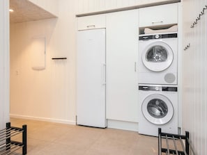 A laundry room with two white washing machines and a white refrigerator.