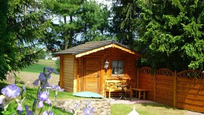 A wooden cabin with a porch, a table, and a bench. - Holiday Home Country House Kathy (Michelstadt)