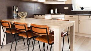 A modern kitchen with a central island, four chairs, and a large window. - Nice Home in Earnewald With Whirlpool and Sauna (Earnewald)