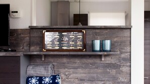 A modern kitchen with a wooden backsplash, a framed nautical-themed artwork, and two decorative candles. - Nice Home in Earnewald With Whirlpool and Sauna (Earnewald)