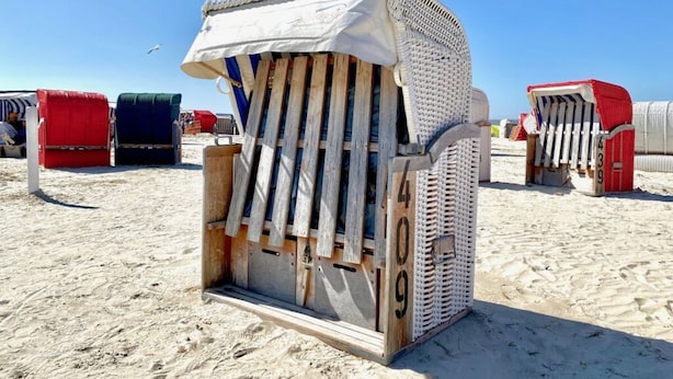 A beach chair with a unique design, featuring a wooden frame and a patterned fabric cover. - Near the North Sea Modern Retreat (Esens)