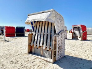 A beach chair with a unique design, featuring a wooden frame and a patterned fabric cover. - Near the North Sea Modern Retreat (Esens)