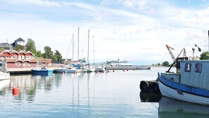 Un puerto con barcos amarrados, una grúa y un edificio con techo rojo.