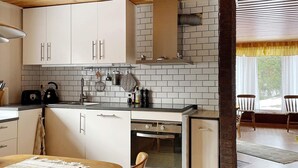 Una cocina moderna con gabinetes blancos, horno empotrado y lavavajillas.