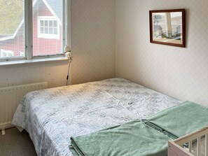 A small, single-bed room with a window, a radiator, a power outlet, and a framed picture on the wall. - 10 Person Holiday Home in Kyrkhult (Kyrkhult)