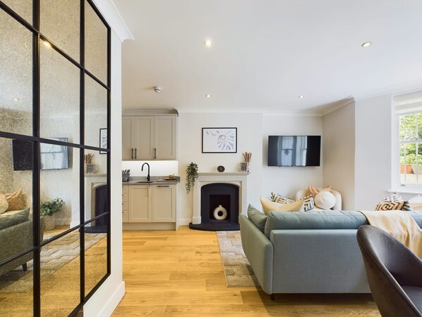 A modern living room with a fireplace, a sofa, and a TV.