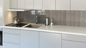 A modern kitchen with a stainless steel sink, a kettle, and a small penguin figurine. - 8 Person Holiday Home in Hovden-by Traum (Bykle)