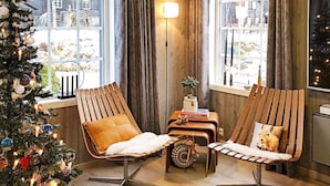 A cozy room with two wooden chairs, a small table with a plant and books, and a Christmas tree. - 8 Person Holiday Home in Hovden-by Traum (Bykle)