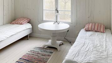 A room with two beds, a round table, and a window.