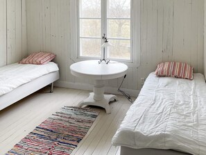A room with two beds, a round table, and a window.