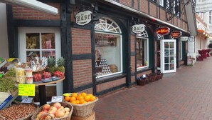 Straßenansicht eines traditionellen europäischen Gebäudes mit einem Obststand davor.
