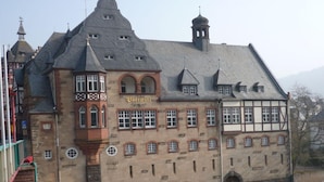En historisk bygning med et markant tårn, mange vinduer og et skilt med teksten "Hotel".