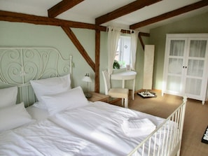 A bedroom with a bed, a small table, a chair, and a wardrobe. - Honer Country House (Steinbergkirche)