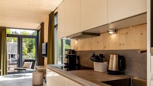 A modern kitchen with a large window, a coffee maker, and a kettle. - Modern Holiday Home With sun Shower (Winterberg)