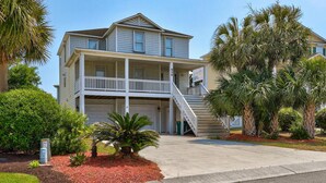 A two-story house with a balcony, a front porch, and a staircase leading to the second floor. - ⚓Anchors Away: Pet-Friendly | Rooftop Deck | 4 Blocks to Beach⚓ (Kure Beach)