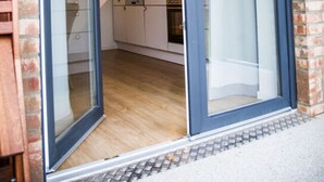 Una cocina moderna con armarios blancos, encimera de madera y una cafetera.