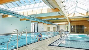 An indoor swimming pool with clear water, tiled floor, and a skylight above. - 6 Person Holiday Park Home in Ebeltoft (Ebeltoft)