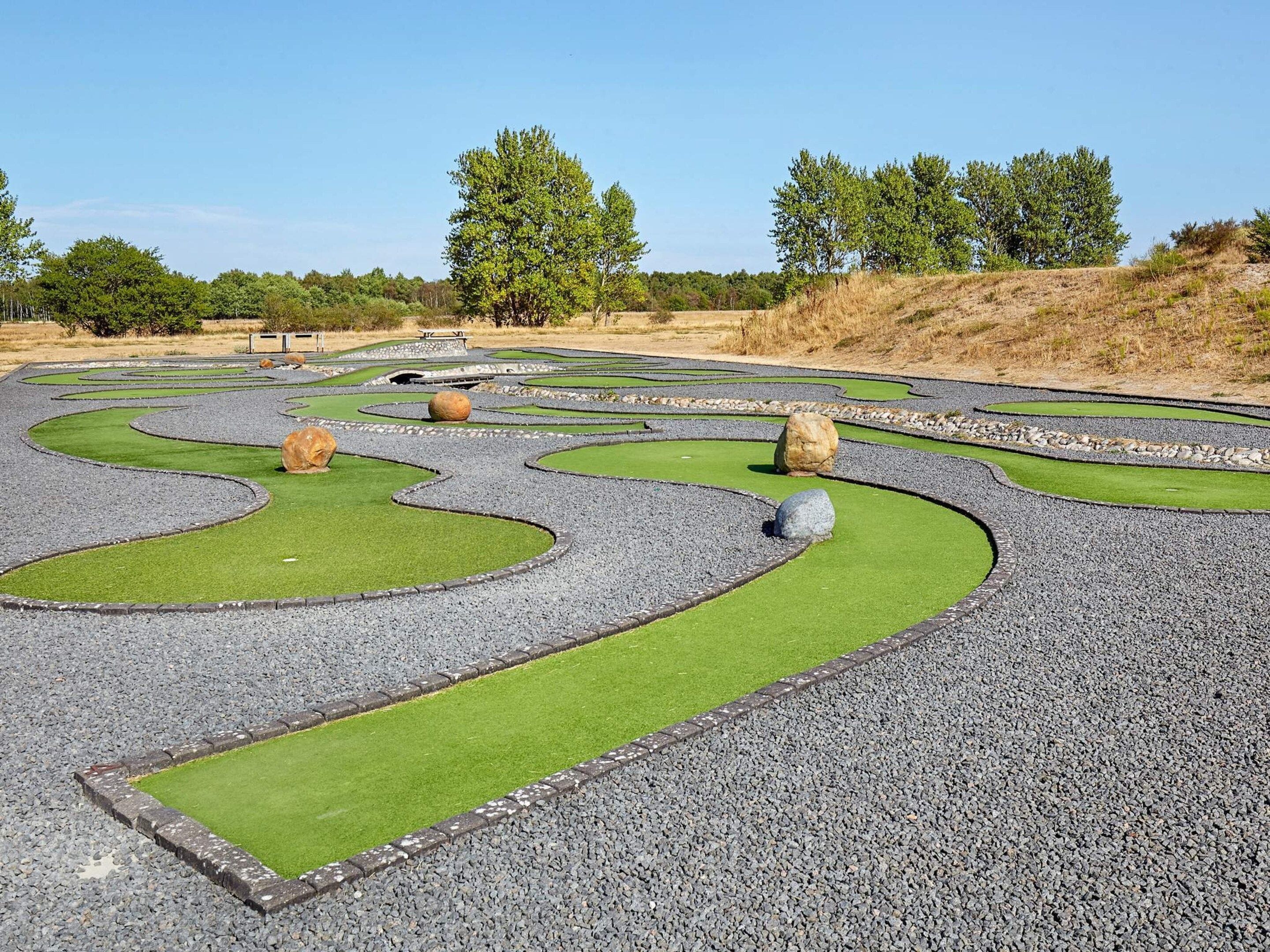 Un jardín ajardinado con senderos sinuosos y áreas verdes.
