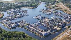 An aerial view of a marina with boats docked, surrounded by greenery and residential buildings. - 6 Person Holiday Park Home in Ebeltoft (Ebeltoft)