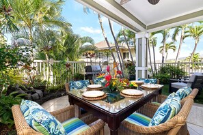 An outdoor patio with a glass-top table, wicker chairs, and a grill. - Kona Sea Ridge#X1: Beautiful 2 level Spacious 3 bedroom with Ac & Ocean Views (Kailua Kona)