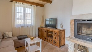 A living room with a wooden ceiling, a television on a wooden cabinet, a fireplace, and a sofa. - Villa Malena Comfortable Holiday Residence (Svetvincenat)