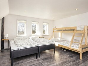 A bedroom with a bunk bed, two bedside tables, and a window with a view of trees. - 5 Star Holiday Home in Grindsted (Grindsted)