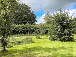 A lush garden with various trees and a grassy lawn. - 5 Star Holiday Home in Grindsted (Grindsted)