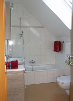 Une salle de bain avec une baignoire, des toilettes et un lavabo.