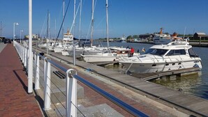 A marina with multiple boats docked along a paved walkway. - Friesengold Modern Retreat (Esens)