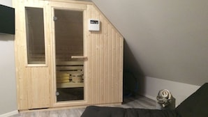 Una stanza piccola con un'armadietto di legno, un materasso e un termosifone.